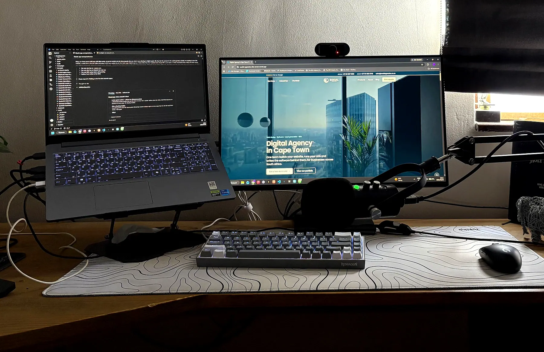 The Social Agencies desk in Cape Town: code on the laptop, the new Social Agencies website on the monitor
